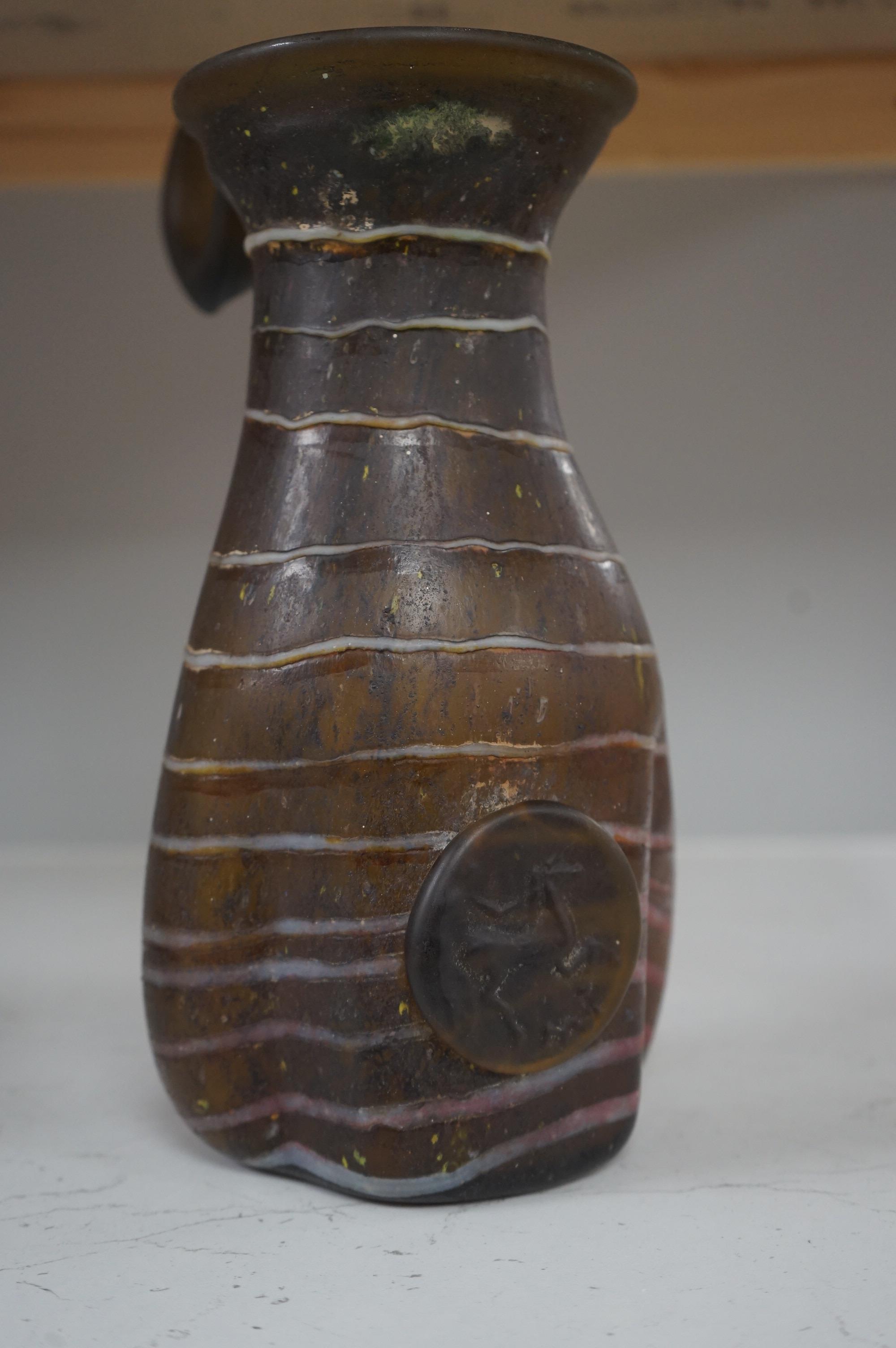 A Roman-type amber and trailed glass ewer with applied roundel, 29cm high. Condition - good